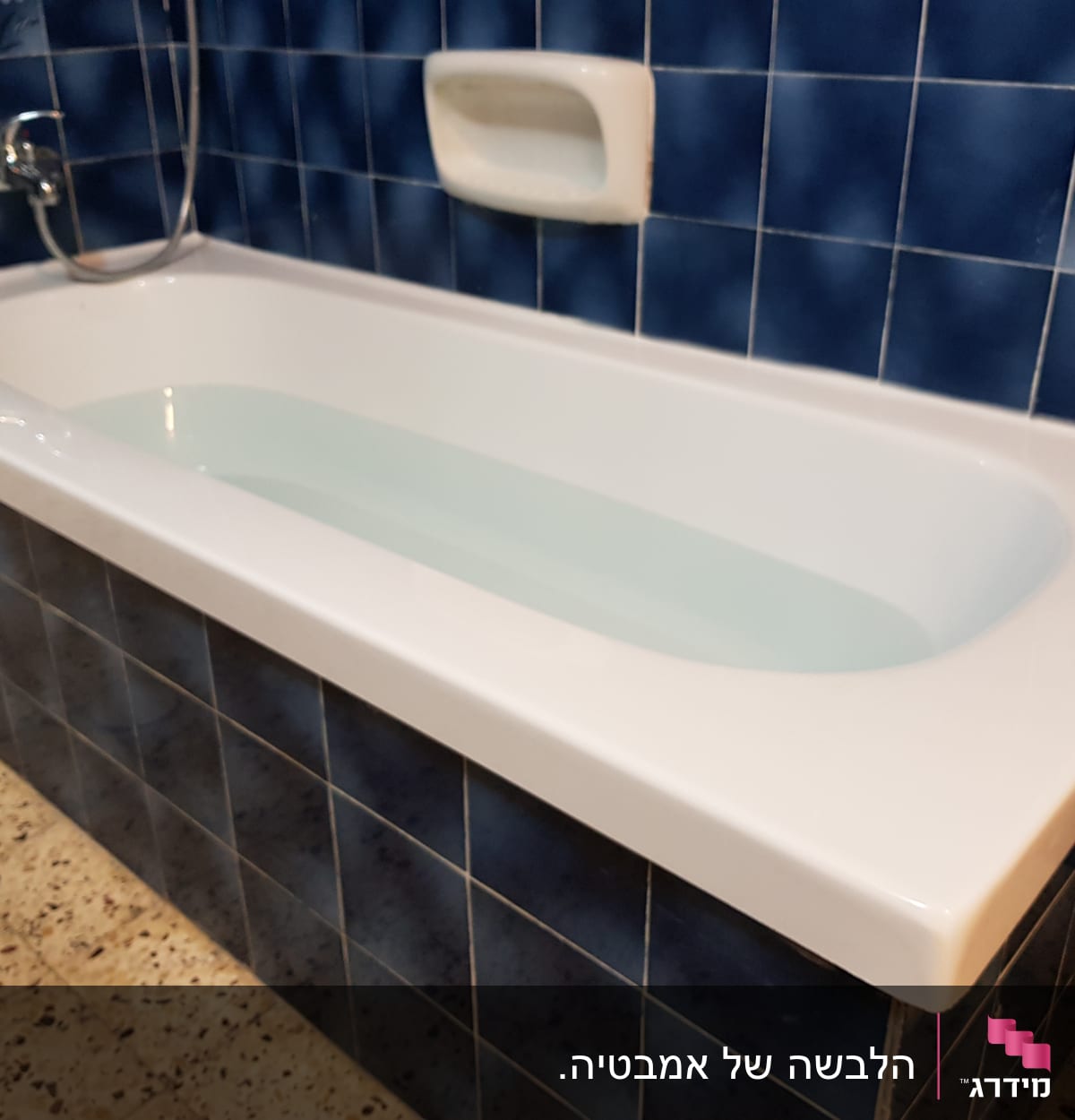 אמבטיה עם חיפוי אריחים כחולים וברז מתכת